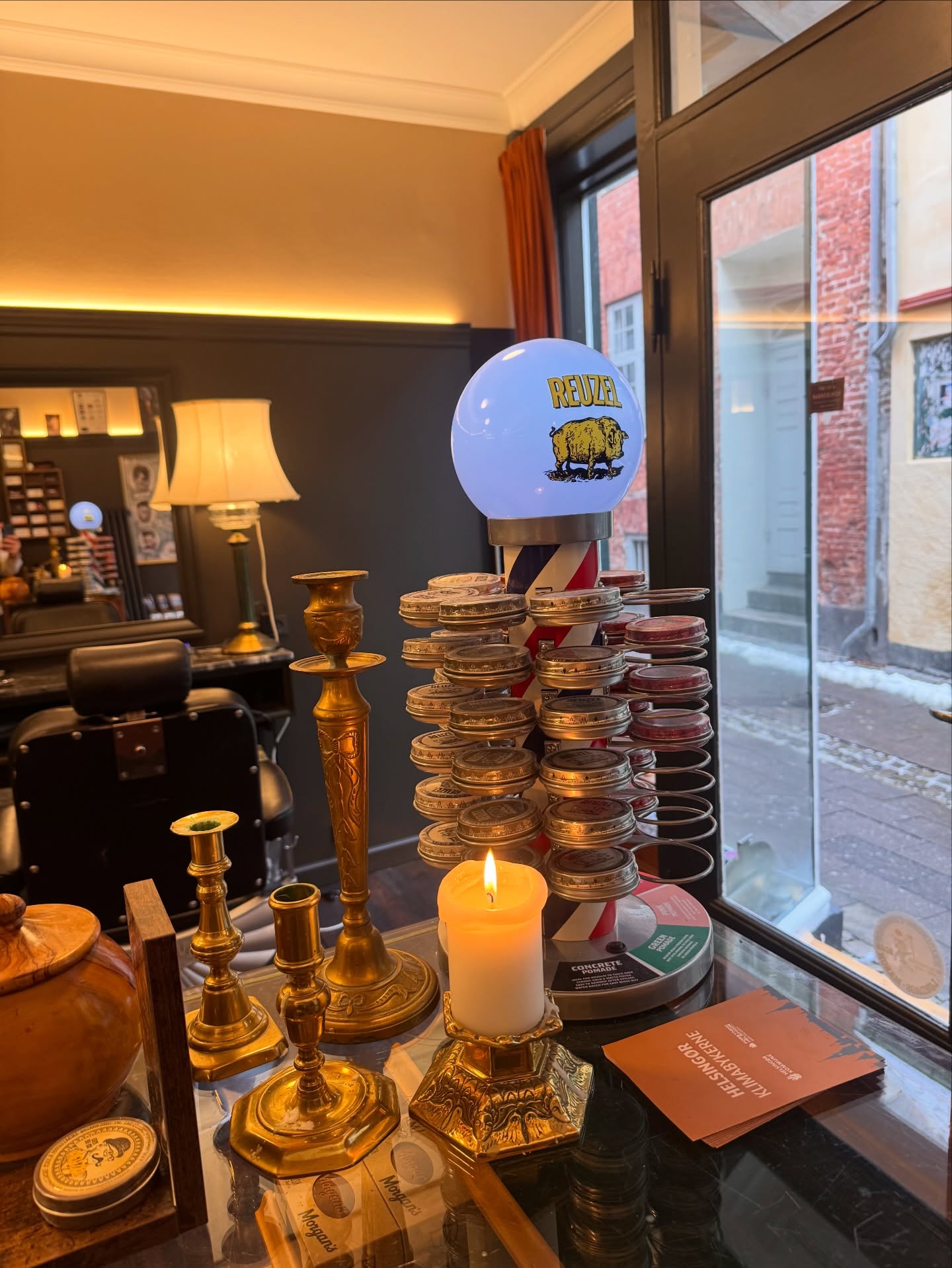 Detalje med barberpole og lysestager i butikken