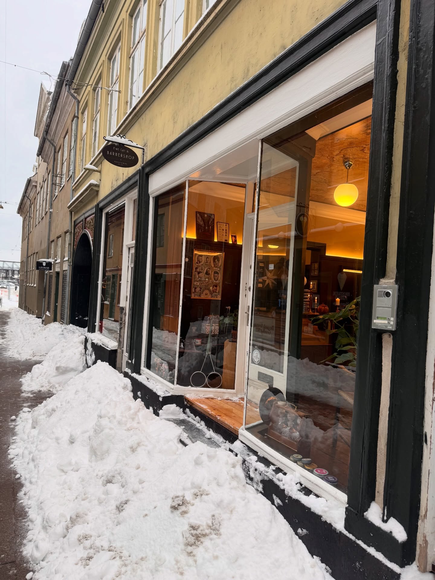 Facaden om vinteren med sne og skiltet Fine Cut & Barbershop