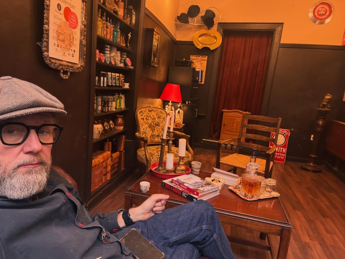 Torben omgivet af vinylplader og whisky i butikkens hyggekrog